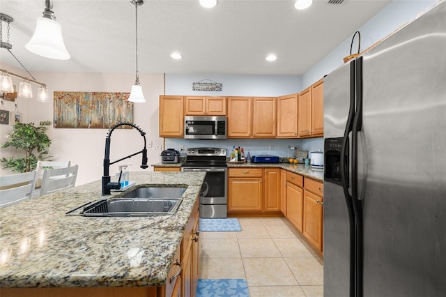 kitchen featuring pendant lighting, sink, light tile patterned flooring, a center island with sink, and stainless steel appliances