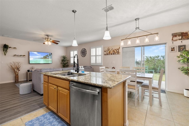 kitchen with decorative light fixtures, sink, dishwasher, and a center island with sink