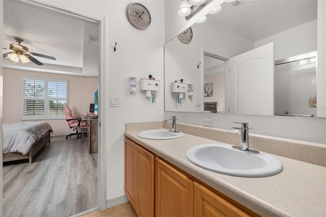 bathroom with vanity, ceiling fan, a textured ceiling, and wood-type flooring