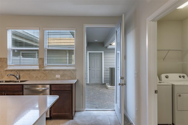 interior space with washing machine and dryer, sink, and light tile patterned flooring