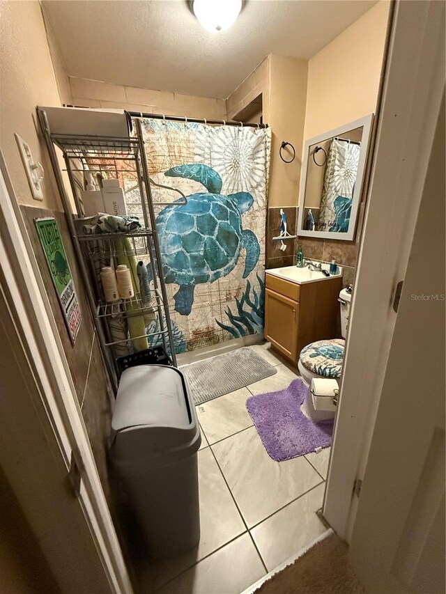 704 N 8th St, Haines City, FL 33844 - bathroom with vanity, tile patterned flooring, toilet, and a shower with shower curtain