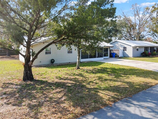 view of front of house featuring a carport, a front lawn, and a sunroom