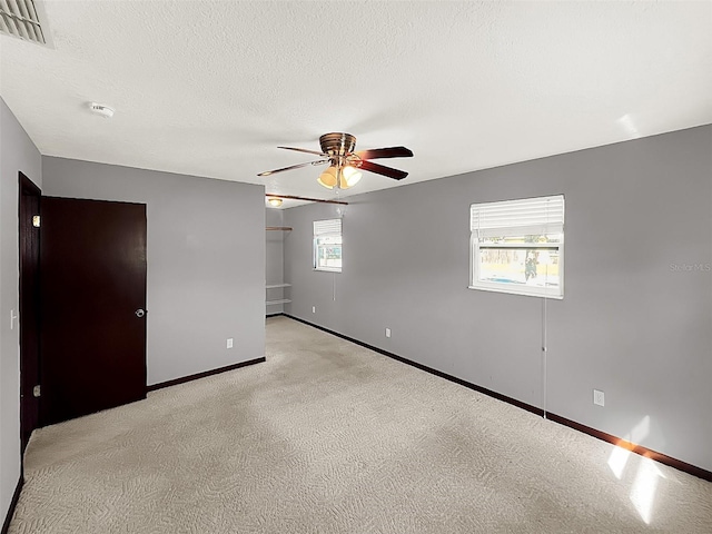 unfurnished room with light carpet, a textured ceiling, and ceiling fan