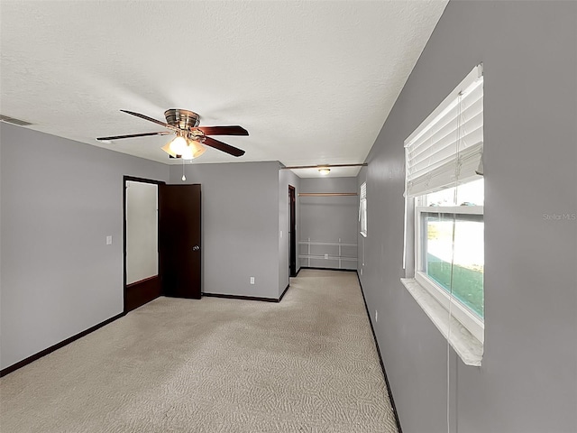 carpeted empty room with ceiling fan and a textured ceiling