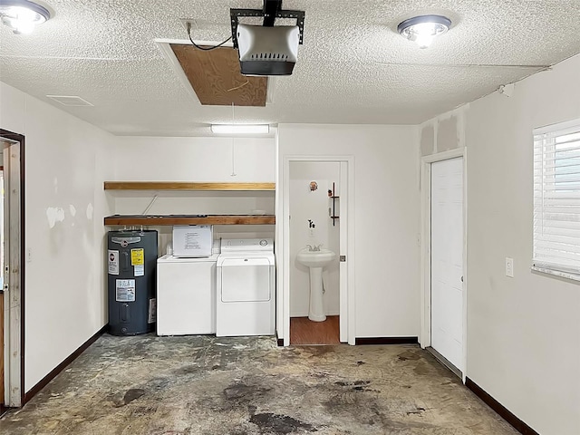 garage featuring washing machine and clothes dryer, a garage door opener, sink, and water heater