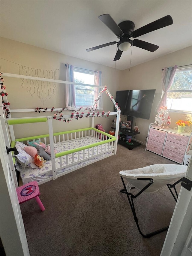 carpeted bedroom featuring ceiling fan and multiple windows