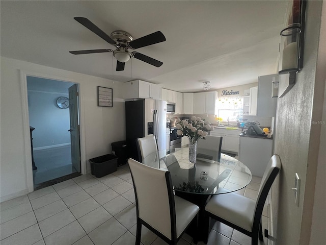 dining area with sink, light tile patterned floors, and vaulted ceiling