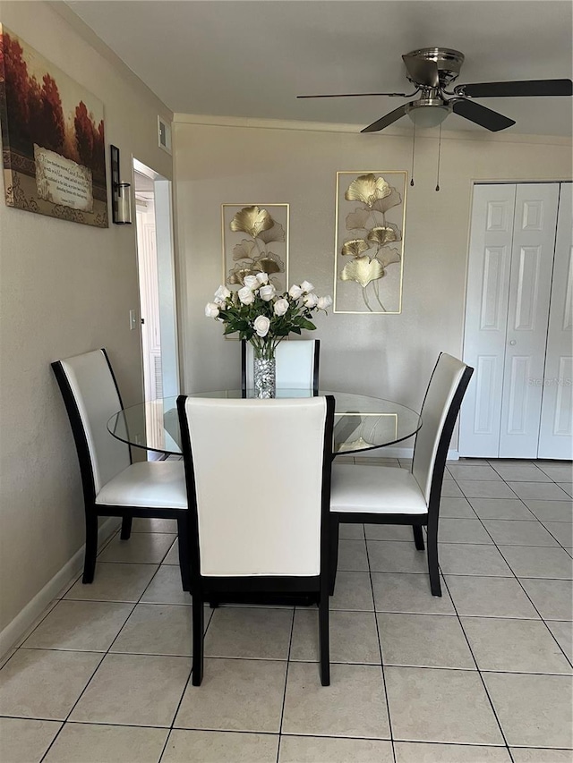 tiled dining space with ceiling fan