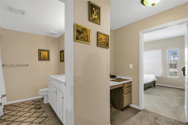 bathroom with a textured ceiling, toilet, and vanity