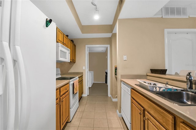 kitchen with sink, white appliances, and light tile patterned flooring