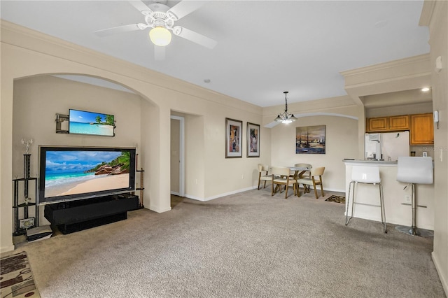 carpeted living room with ceiling fan and crown molding