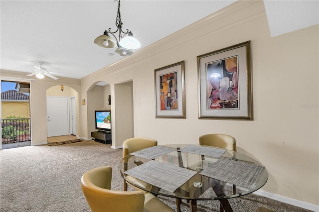 dining space featuring ceiling fan with notable chandelier, carpet, and ornamental molding