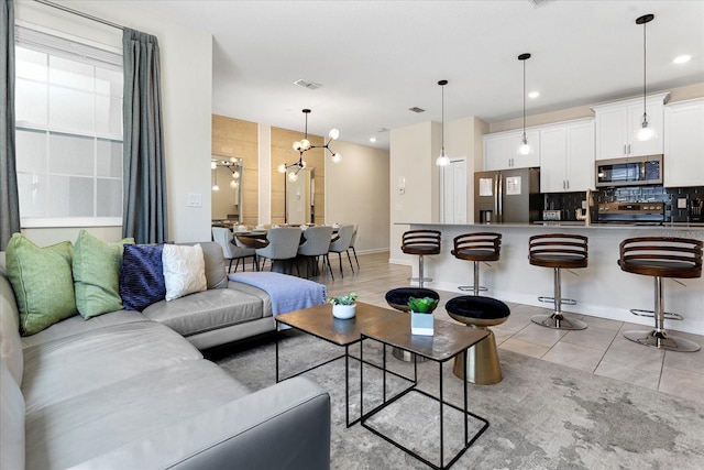 tiled living room featuring a chandelier