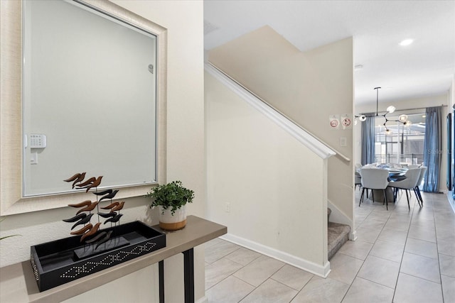 tiled foyer entrance featuring an inviting chandelier