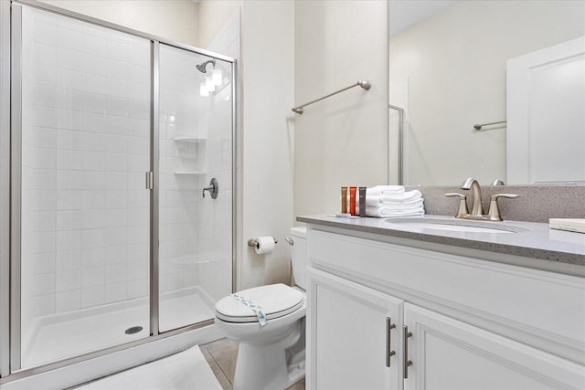 bathroom featuring vanity, tile patterned floors, a shower with door, and toilet