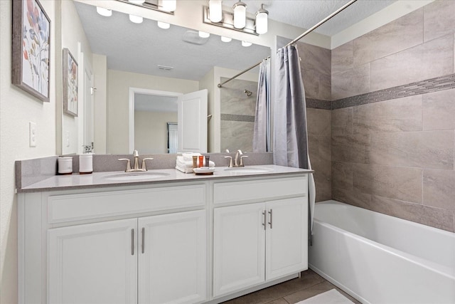 bathroom with shower / bath combo, tile patterned floors, vanity, and a textured ceiling