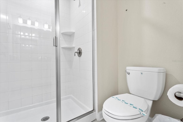 bathroom featuring an enclosed shower and toilet