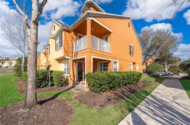 view of front of home with a balcony and stucco siding