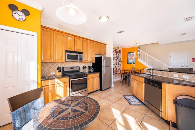 kitchen featuring appliances with stainless steel finishes, backsplash, a sink, and visible vents