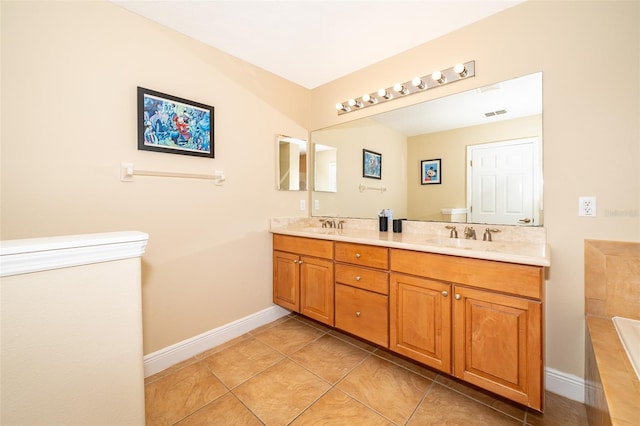 bathroom featuring double vanity, a relaxing tiled tub, a sink, and tile patterned floors