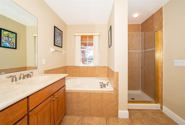 bathroom featuring a stall shower, vanity, tile patterned flooring, baseboards, and a bath