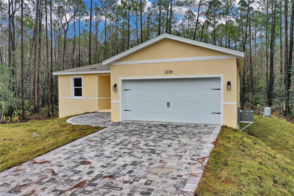 single story home with a garage and a front lawn