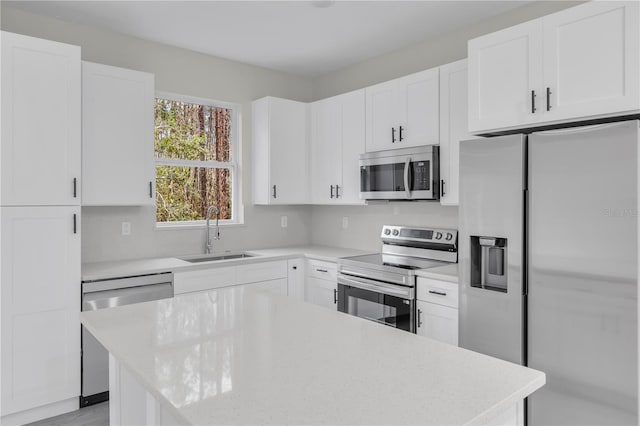 kitchen featuring sink, light stone countertops, white cabinets, and appliances with stainless steel finishes