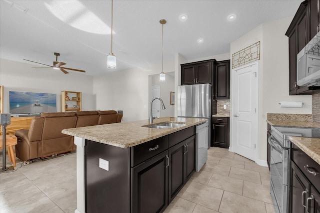 kitchen featuring tasteful backsplash, sink, decorative light fixtures, an island with sink, and stainless steel appliances