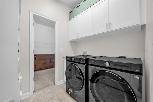 laundry area with light carpet, washing machine and clothes dryer, and cabinets