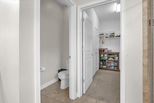 bathroom with tile patterned floors, a textured ceiling, and toilet