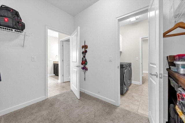 corridor with light tile patterned floors and washer and dryer