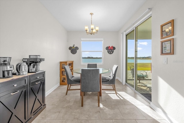 dining area featuring a notable chandelier and a water view