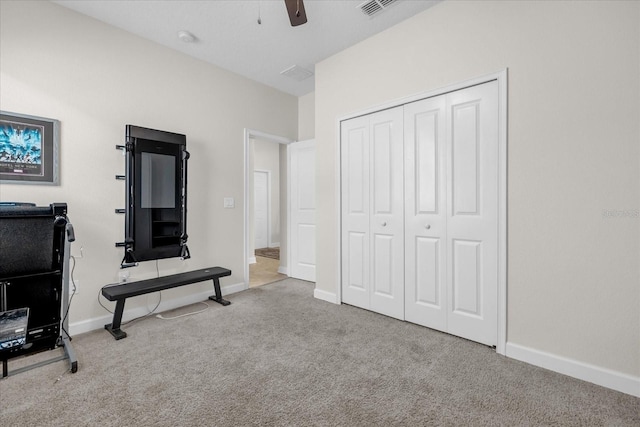 workout area with light colored carpet and ceiling fan