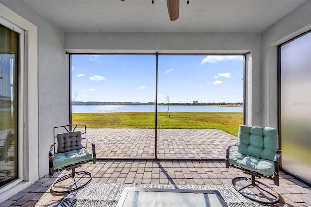 sunroom / solarium featuring a water view