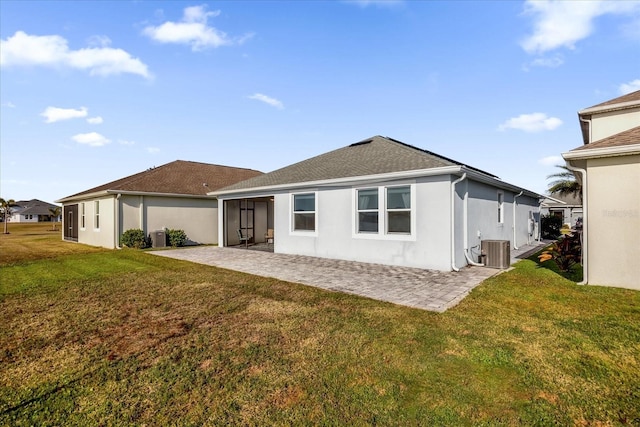 rear view of house featuring a patio, central AC, and a yard