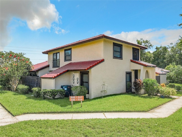 mediterranean / spanish home with a front yard and central AC