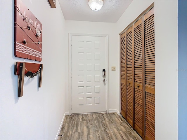 entryway with wood-type flooring and a textured ceiling