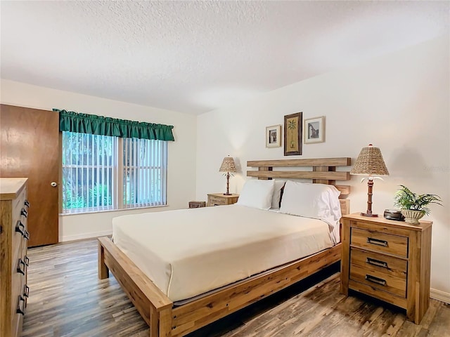 bedroom featuring a textured ceiling and hardwood / wood-style floors