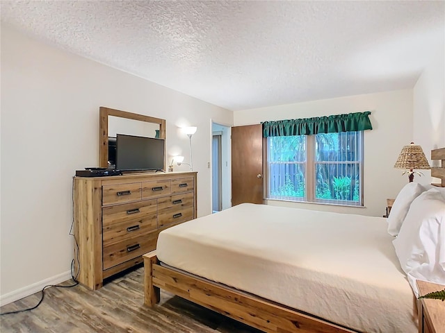 bedroom featuring a textured ceiling and hardwood / wood-style flooring