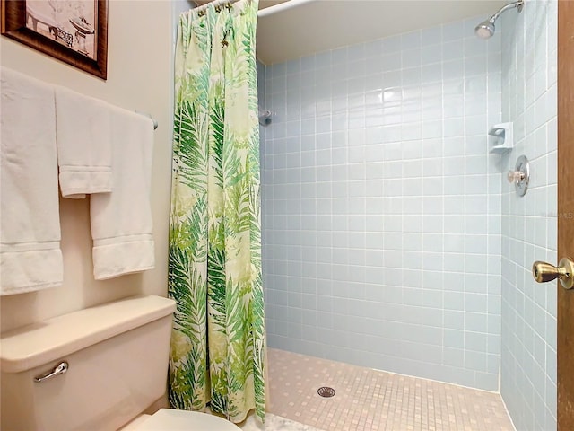 bathroom featuring toilet and curtained shower