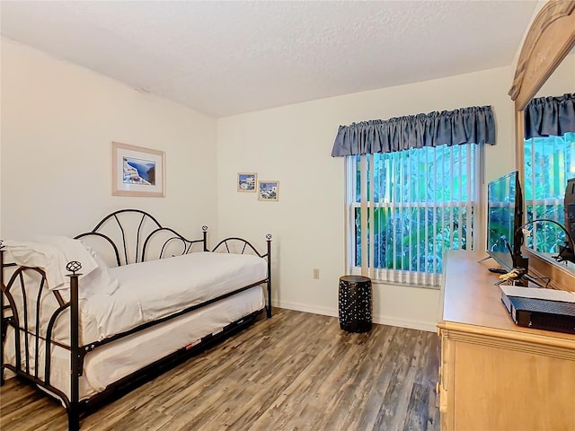 bedroom with a textured ceiling and hardwood / wood-style floors