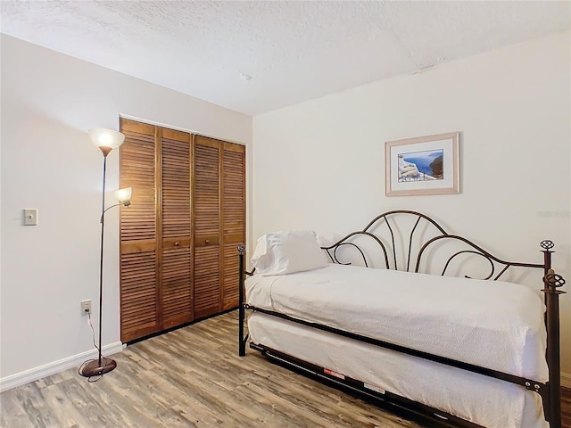 bedroom featuring a textured ceiling, a closet, and hardwood / wood-style flooring