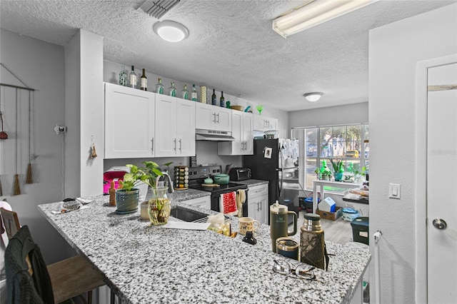 kitchen with black appliances, white cabinets, kitchen peninsula, a breakfast bar, and light stone counters