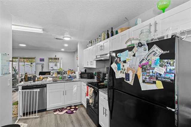 kitchen with sink, black appliances, white cabinetry, and a textured ceiling