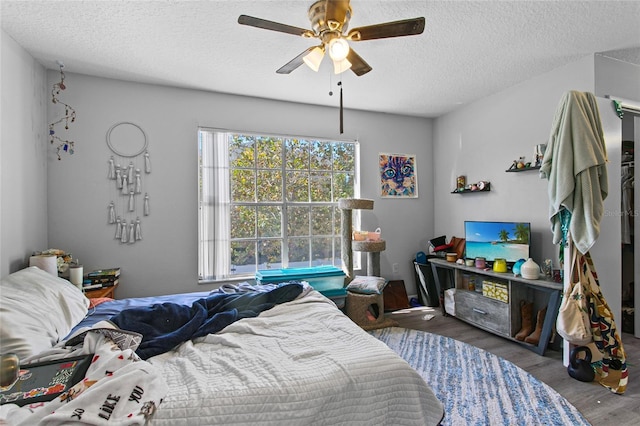 bedroom featuring hardwood / wood-style floors, a textured ceiling, and ceiling fan