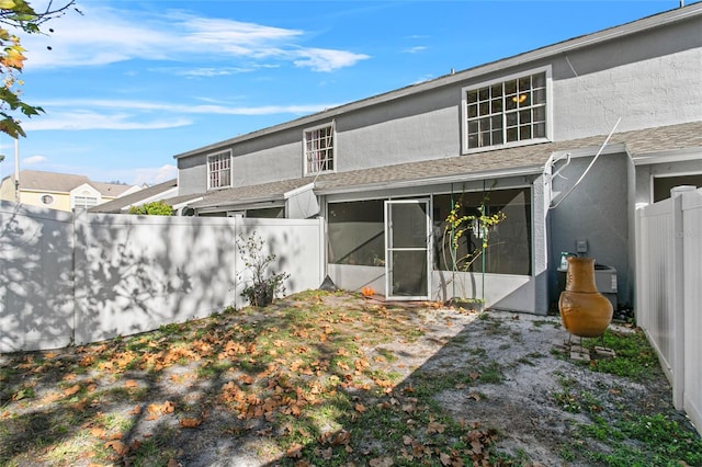 rear view of house featuring a sunroom