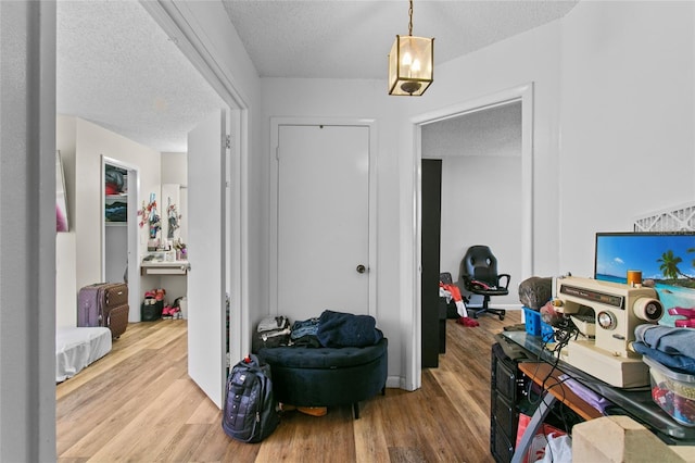 home office featuring light hardwood / wood-style flooring and a textured ceiling