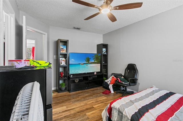 bedroom featuring ceiling fan, a textured ceiling, and wood-type flooring