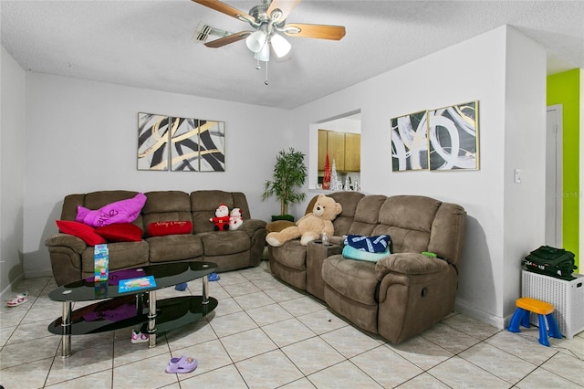 living room with ceiling fan, light tile patterned floors, and a textured ceiling