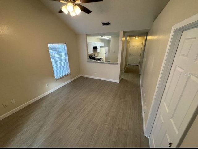 unfurnished living room with hardwood / wood-style flooring, vaulted ceiling, and ceiling fan